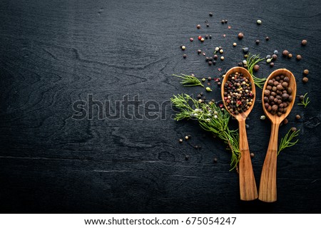 A set of fragrant spices. A mixture of black and red pepper, coriander, paprika. On Wooden background. Top view. Free space.