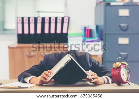 Businessman making mistake about financial business.Exhausted and tired worker surrendering to fatigue working and sleepy worker on desk with laptop on head after late night work at office.Overworking Royalty-Free Stock Photo #675065458