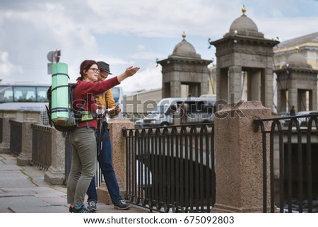 Young couple of tourists check the route on the navigator