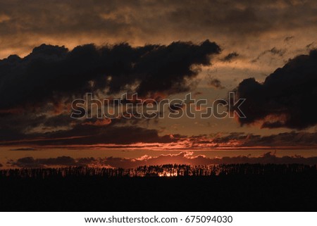 Sunset against the background of the evening sky with colorful shades of the clouds