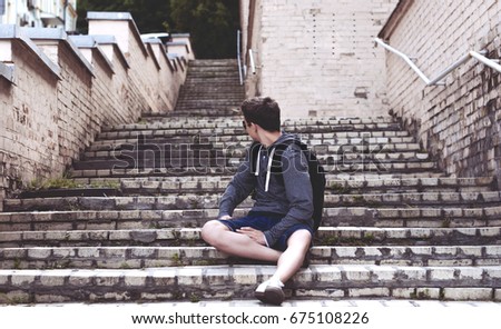 Teenager sitting on the stairs on the city street