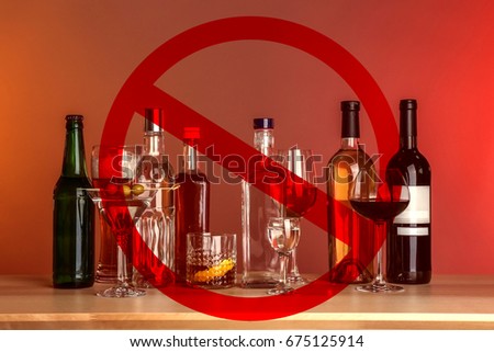 Different alcohol drinks in glassware with STOP sign on red background