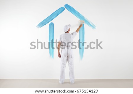 home service concept. painter man with brush drawing a blue house isolated on the blank white wall