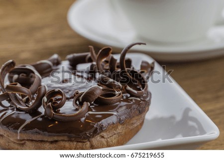 Donut chocolate and latte coffee on wooden table,