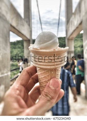 Ice cream cone holding on woman hand in nature background