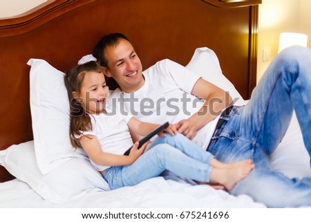 Father and his daughter watching TV.