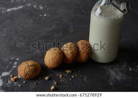 Cookies with chocolate and peanuts. A bottle of milk.
