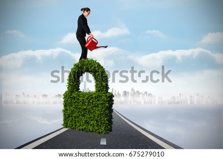 Businesswoman using red watering can against open road background