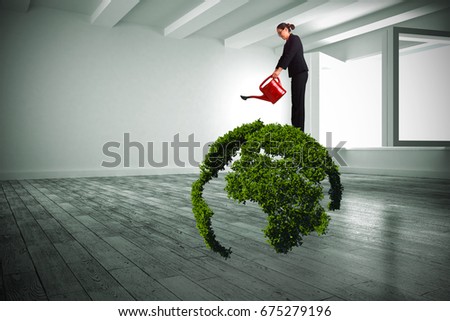Businesswoman using red watering can against white room with windows
