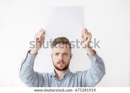 Tensed Man Holding Sheet of Paper Above Head