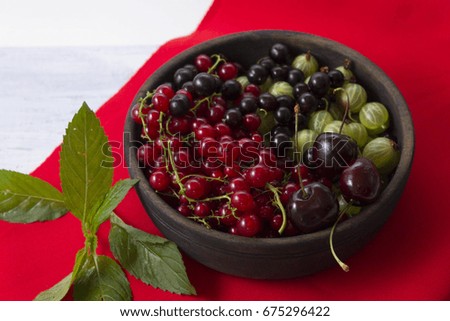 Gooseberries and red currants in a wooden bowl. Ripe and fresh berries. Summer time.