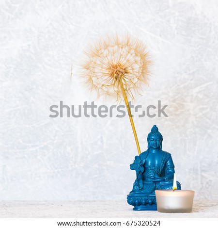 Buddha, burning candle and dandelion flower as zen background