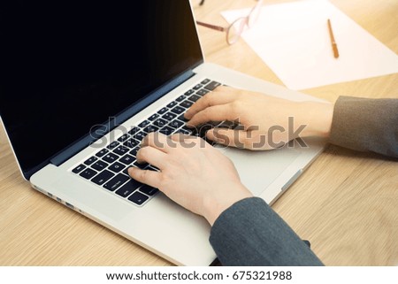 business woman working on laptop computer while sitting in wood table