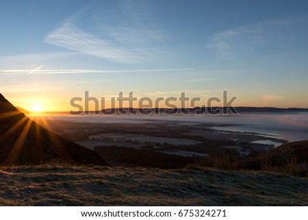 Sunrise from the top of Conic hill locking over the towns and villages below. Scotland UK