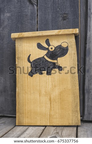 Wooden sign with dog picture.