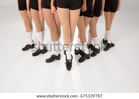 Dancers in fifth position in a wedge formation with lead dancer en pointe