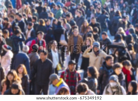 Defocused picture of crowd of people at the city 