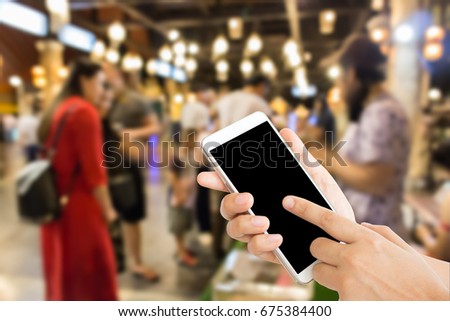 woman use mobile phone and blurred image of people at the animals show in the night street market