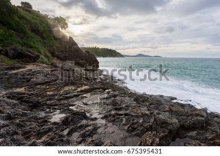 Rocky cape in Phuket, Andaman Sea, landscape in cloudy weather, rocks and bushes on the shore