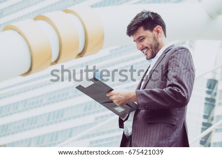 Businessman reading report successful with smile on building background in city