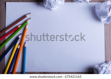 Colored pencils on white paper back to school concept - sheet of white paper with pencils and drafts