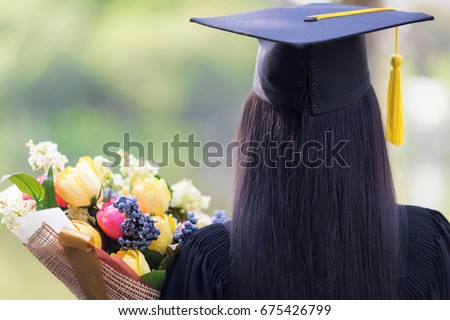 Educational theme.Woman graduating and Beautiful bouquet of congratulations in an academic gown. Royalty-Free Stock Photo #675426799