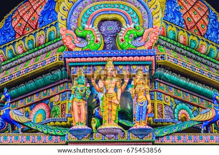Colorful night view of indian gods sculpture at Sri Maha Mariamman Temple, also known as Maha Uma Devi temple, the public hindu temple in Silom, Bangkok, Thailand. It known as Wat Khaek Silom. Royalty-Free Stock Photo #675453856