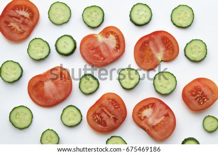 Fresh slices of cucumbers and tomatoes. Isolated on white background. View from above