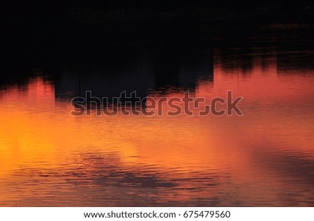 Abstract background. Buildings and sunset sky reflection in the water.