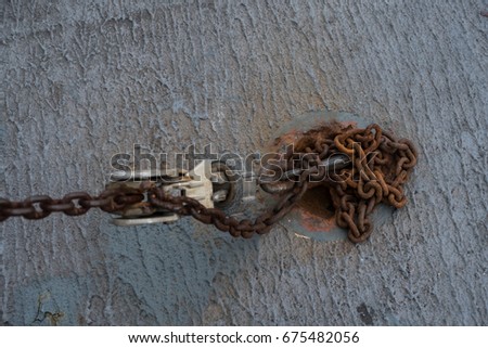 Rustic chained and hook on concrete floor, selective focus