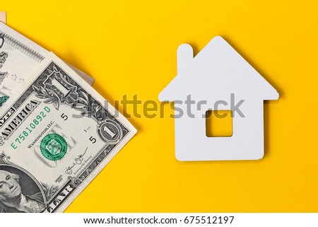 White papercut house near money - dollars banknotes