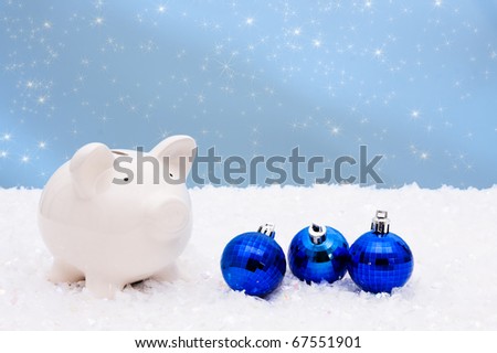 Blue christmas bells with a piggy bank on a snow and blue background, christmas savings