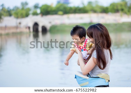 Mother and her child enjoy the summer in green park outdoor.