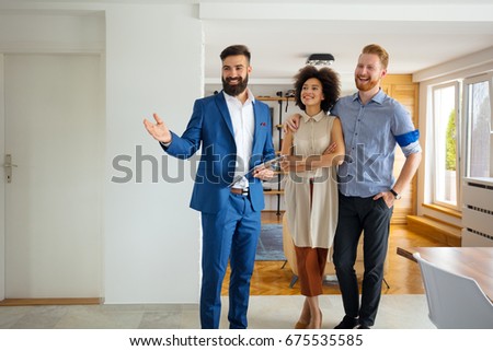 Happy family with real estate agent inside house for sale.