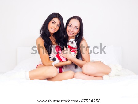 beautiful  brunette girls with their dog on the bed