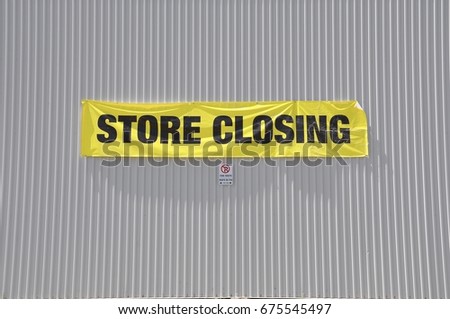 Store closing sign hanging on the concrete wall