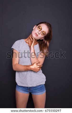 concept creative make-up with use of glitter and paint, which shimmers in different colors. a slender, young woman posing in photo Studio. emotional portrait