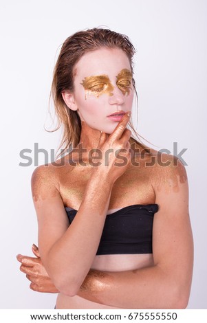 concept creative make-up with use of glitter and paint, which shimmers in different colors. a slender, young woman posing in photo Studio. emotional portrait. athletic body