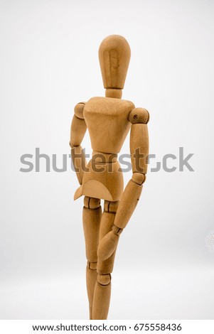Wooden figure isolated on white background. Dummy in fashionable posing concept.