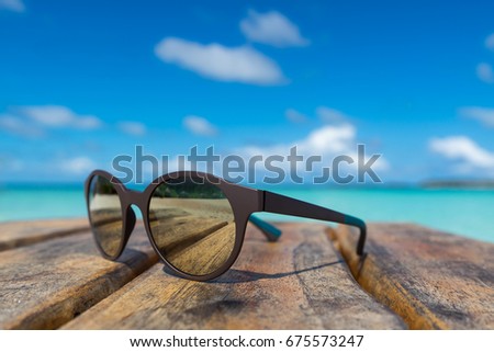 Picture of sunglasses on the tropical beach, vacation. Traveler dreams concept