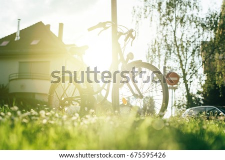 Beautiful modern city urban bicycle parked on a street in calm town with majestic sun flare sunlight behind - sport concept, staying fit concept, going to work by bike at sunset or sunrise