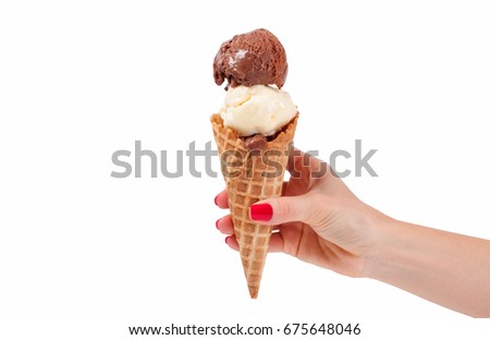 Chocolate and vanilla ice cream cone on white background. Hand holding ice cream in wafer cup.
