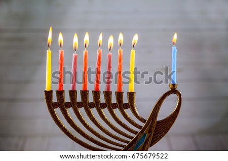 low key image of jewish holiday Hanukkah with menorah traditional Candelabra and wooden dreidels spinning top . glitter overlay