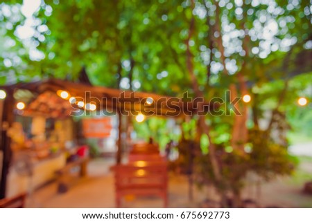vintage tone blur image of restaurant in the garden on evening time for background usage.
