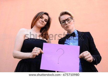Girls are holding, a cardboard with question mark drawn