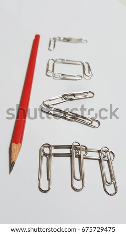 LOVE Text by metal paper clips and Red pencil on the white papers, perspective view