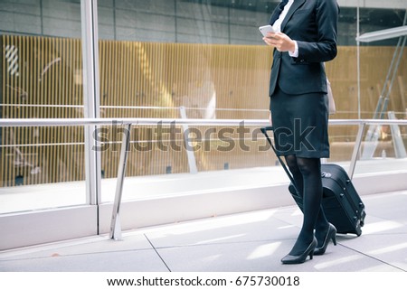 young businesswoman looking smart phone while walking. Royalty-Free Stock Photo #675730018