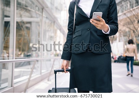 young businesswoman looking smart phone while walking. Royalty-Free Stock Photo #675730021