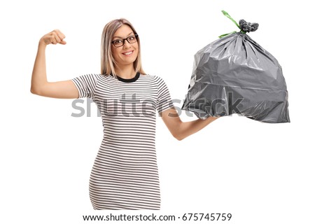 Young woman flexing her biceps and holding a garbage bag isolated on white background