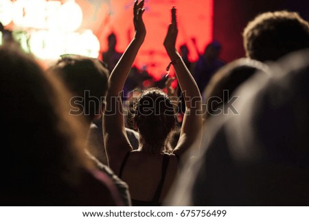 Photo of many people enjoying rock concert, audience applauding to musician band, night entertainment, music festival, happy youth, luxury party